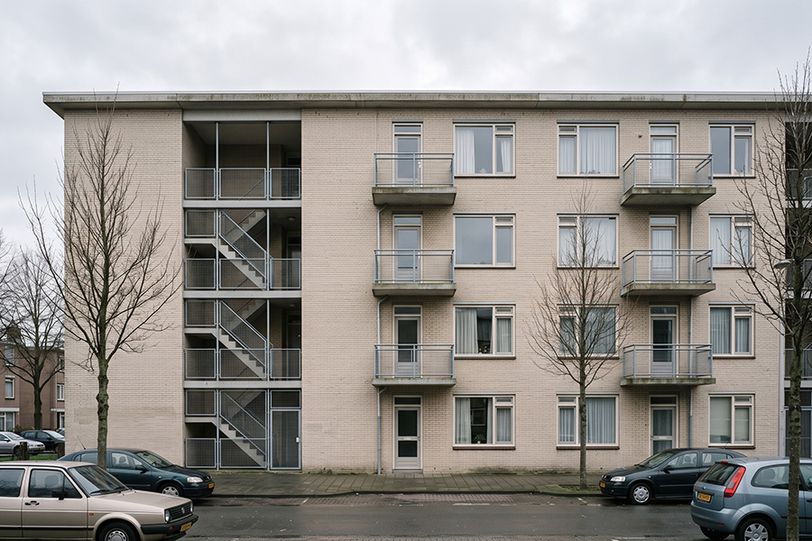 Naoorlogse portiekflat van vier lagen in lichte baksteen, met open trappenhuis en betonnen balkons
