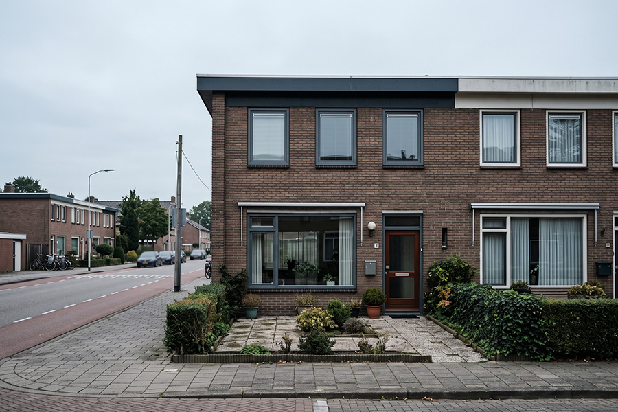 Hoekwoning uit de jaren 70 met een plat dak en een brede pui